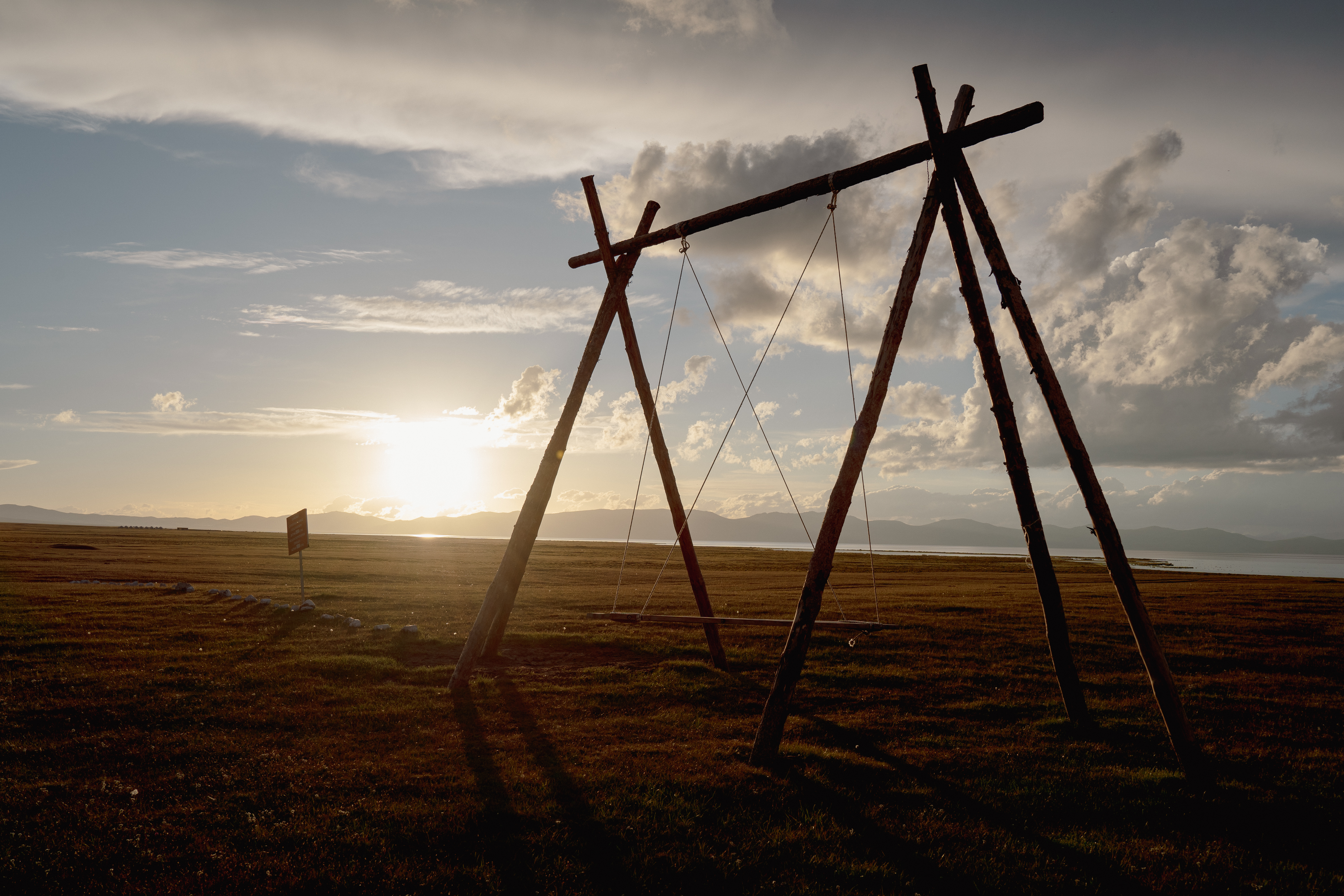 Wooden swing at sunset on Son-Kul